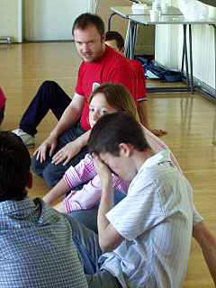 Young people in rehearsal with director Phil Hoffman (in red)